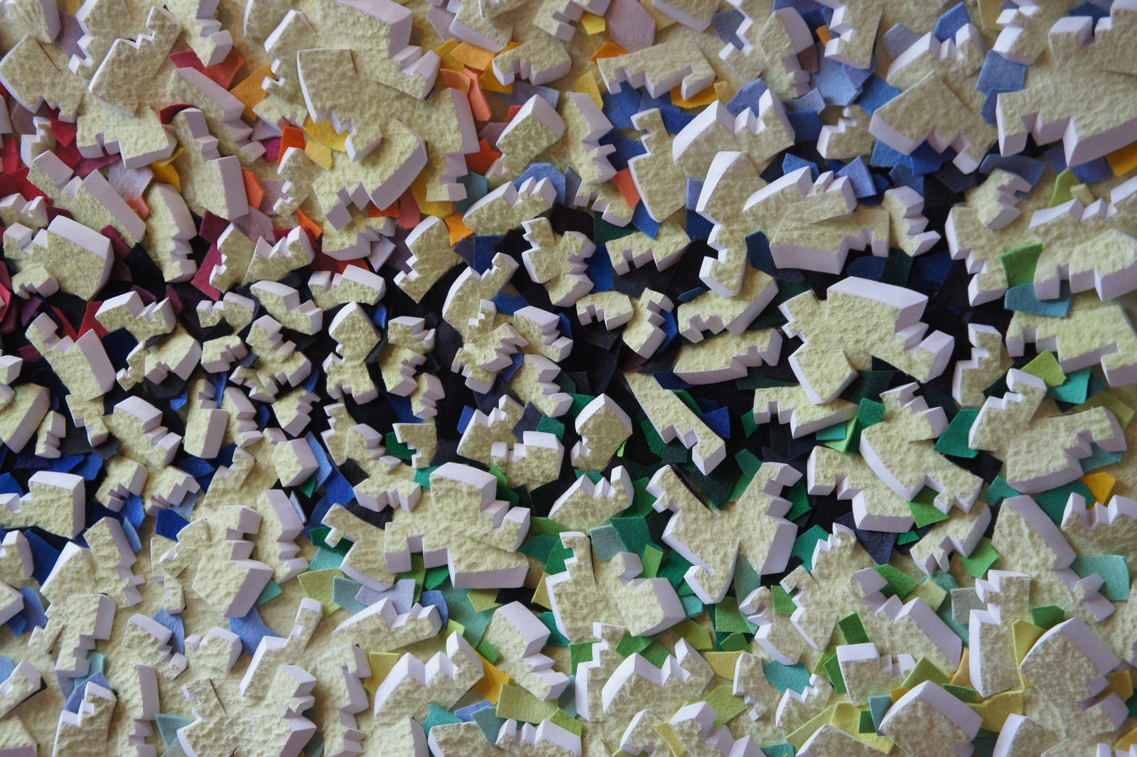 Gelbe reliefartige Formen mit weißen Seiten und blauen, grünen und dunklen Zwischenlagen.